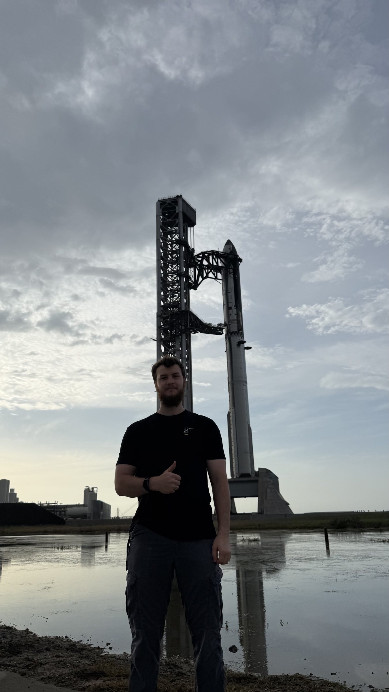 Sterling Pearson in front of Starship stacked on the launch tower at Starbase, Texas